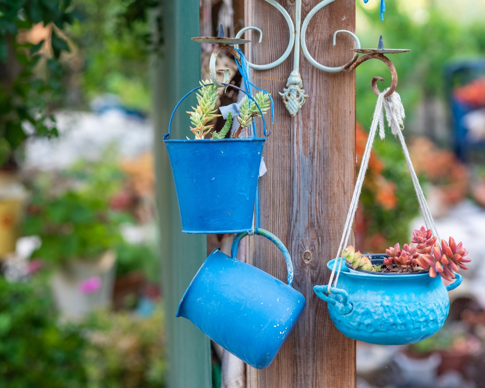 Upcycled garden planters painted with blue paint and plant with succulents