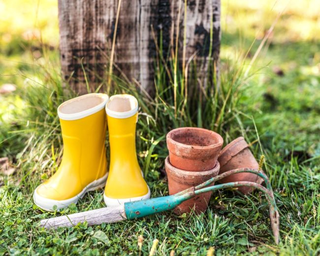 Gardening equipment, yellow wellies, pots and rake