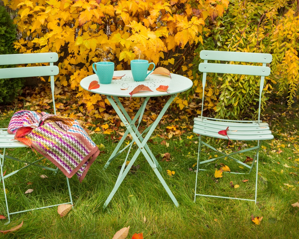 Mint green bistro set with autumn leaves and blanket