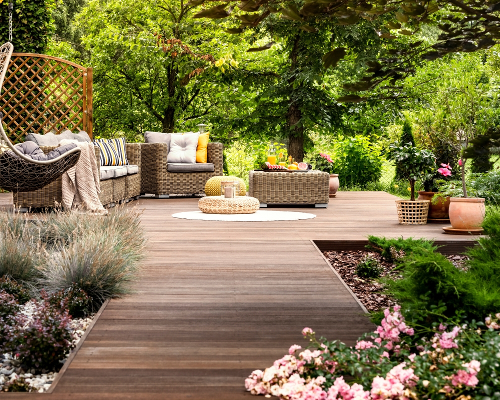 Secluded garden seating area with hanging egg chair and sofa